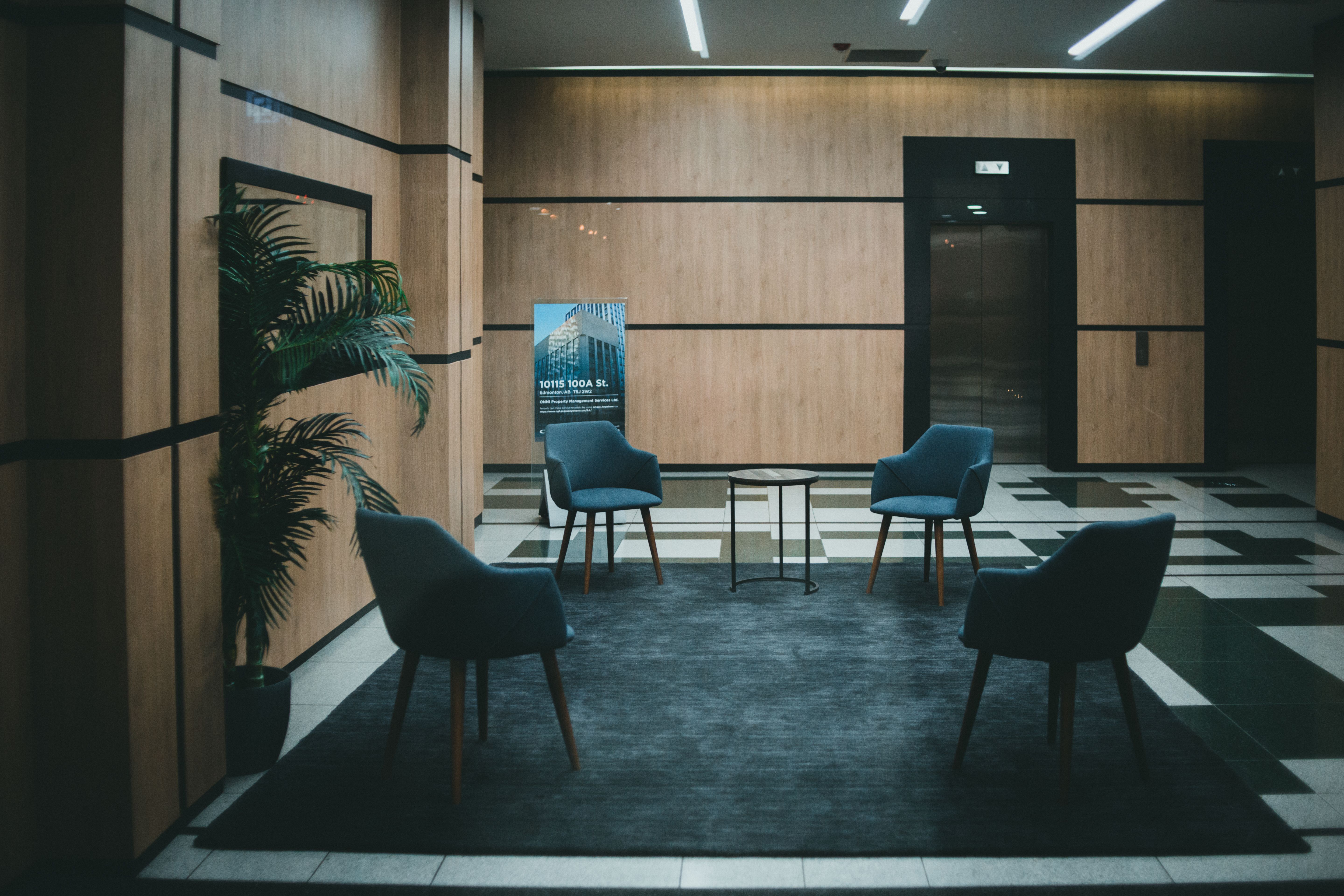 A stylish office lobby featuring chic chairs and a minimalistic design with a neutral tone.