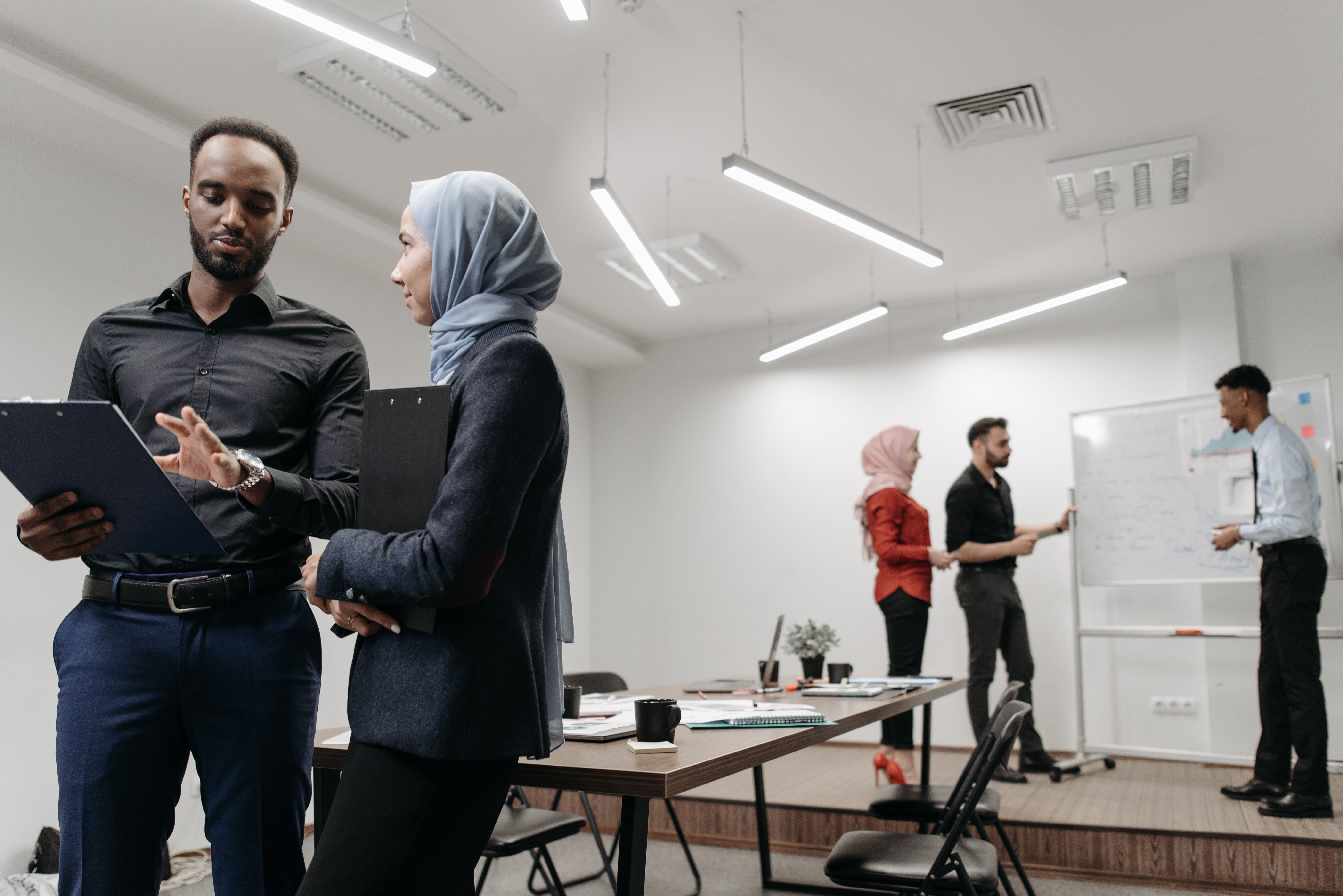 Professional colleagues engage in collaborative discussion in a modern office setting.