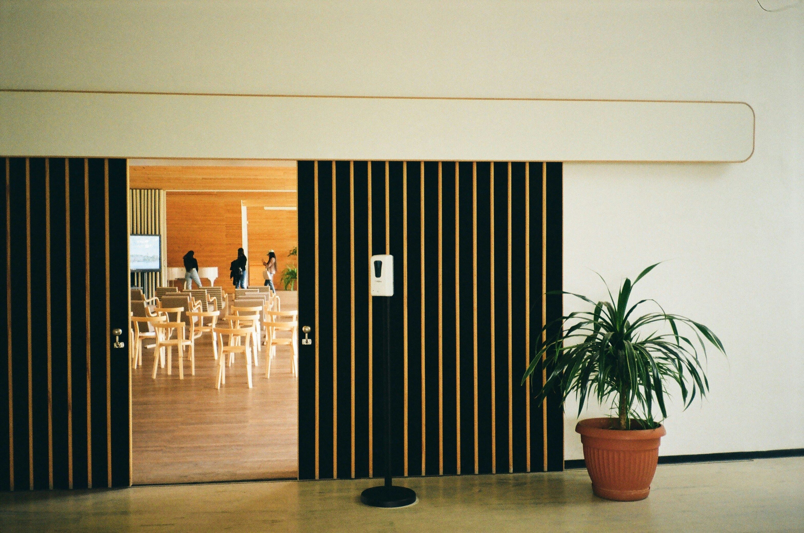 Open doors reveal a modern hall with chairs and plants in Vyborg, Russia.